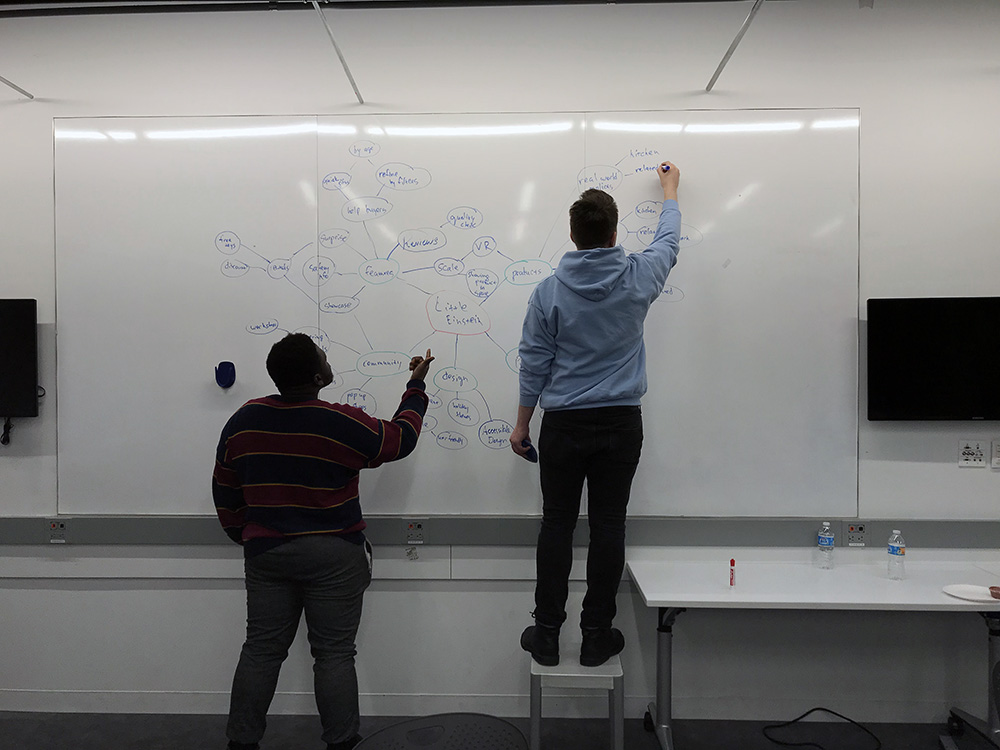 two men standing in front of whiteboard